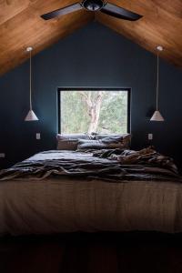 a bedroom with a ceiling fan and a window at Stillwood Retreat - Secluded Boutique Escape, Denmark, Western Australia in Denmark
