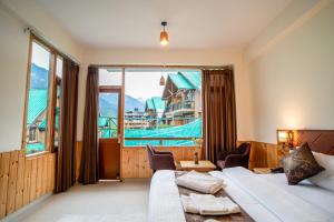 Una habitación de hotel con una cama y una ventana grande. en Dhrisha Mohatsav By Alcor, en Manali