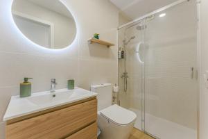 une salle de bain avec toilettes, lavabo et miroir dans l'établissement Vista Magica Beachfront Suite, à Acantilado de los Gigantes