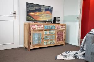 a television on top of a wooden entertainment center at App. Hussmann 8/17 in Westerland (Sylt)