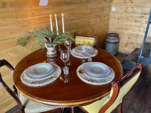 a wooden table with plates and candles on it at Casa Aristocrată - La noi la munte in Mătişeşti