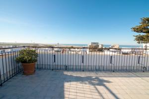 a fence on a balcony with the ocean in the background at Hostal Casa Alborada in Conil de la Frontera