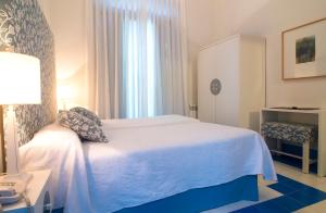 a hotel room with a white bed and a window at Hostal Casa Alborada in Conil de la Frontera