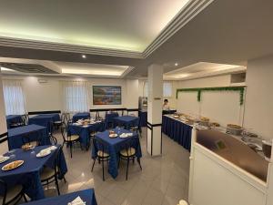 a restaurant with blue tables and chairs and a whiteboard at Hotel Sport in Rimini