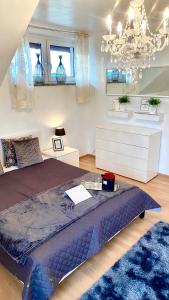 une chambre avec un grand lit et un lustre dans l'établissement VILLA SUNSHINE "SUNSHINE SUITE" NAD JEZIOREM KOMINEK i WANNA w SALONIE OGRóD BALKON, à Lipnica