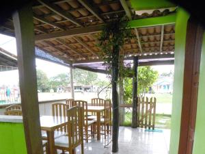 a porch with chairs and a table with a plant at Pousada Casa Verde Boipeba in Ilha de Boipeba