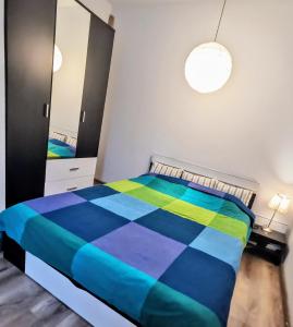 ein Schlafzimmer mit einem bunten Bett und einem Spiegel in der Unterkunft House with a garden in Pipera in Bukarest