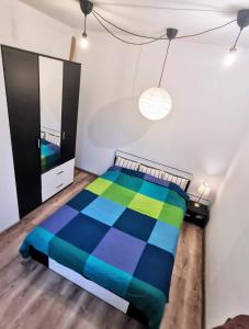 ein Schlafzimmer mit einem bunten Bett und einem Spiegel in der Unterkunft House with a garden in Pipera in Bukarest