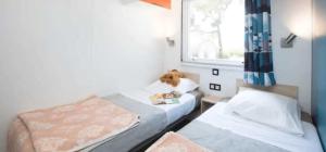 カネ・アン・ルシヨンにあるCamping 4 étoiles - Piscine - ccaaeagのベッドが2つと窓がある小さな部屋 +24枚の写真