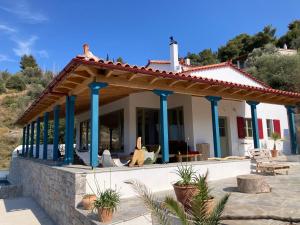 a house with blue columns and a patio at Vanua house in Galatas