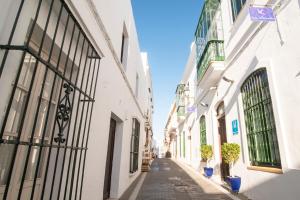 an alley in an old town with white buildings at Hostal Casa Alborada in Conil de la Frontera