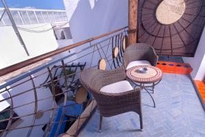 a balcony with two chairs and a table on a balcony at Hostal Casa Alborada in Conil de la Frontera