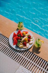 a plate of fruit on a table next to a swimming pool at La Dia Hotel Faralya in Fethiye