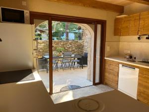 a kitchen with an open door to a patio at La Part des Anges in Saint-André-Capcèze