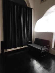 a room with a chair and a window with a black curtain at Pyrgi Artemis Place in Mikonos +59 photos