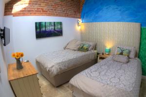 1 dormitorio con 2 camas y un cuadro en la pared en The Orangery, en Thurning