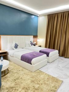 two beds in a hotel room with purple sheets at NOUAKCHOTT HOTEL Towva in Nouakchott +31 photos