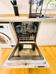 a dishwasher with its door open in a kitchen at 3BR House-Apartment-Free Parking-Manchester Airport in Manchester