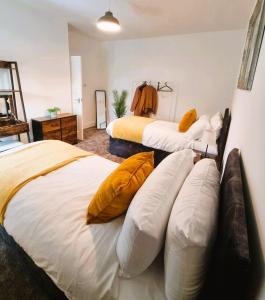 a bedroom with two beds with yellow pillows at 3BR House-Apartment-Free Parking-Manchester Airport in Manchester