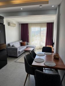 een woonkamer met een tafel en een bank bij Apartment wıth jacuzzı and pool 10 mınutes from the DeadSea in Fethiye