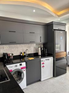 een keuken met een wasmachine en een wasmachine bij Apartment wıth jacuzzı and pool 10 mınutes from the DeadSea in Fethiye +3 foto's