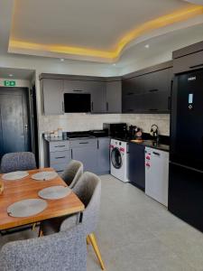 een keuken met een houten tafel en een tafel met stoelen bij Apartment wıth jacuzzı and pool 10 mınutes from the DeadSea in Fethiye