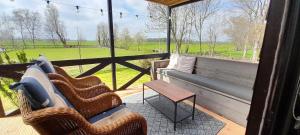 a porch with wicker chairs and a couch and a table at No Milk today in Scherpenzeel
