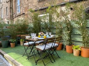 a table and chairs in a garden with plants at The Broughton Townhouse in Edinburgh