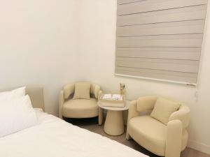a bedroom with two chairs and a bed and a table at You Rou De Di Fang in Huxi
