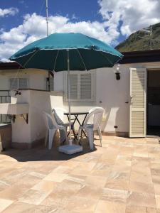 a table and chairs with an umbrella on a patio at Bright Space in a Superb location in Praia a Mare +12 photos
