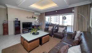 Una sala de estar con un sofá de cuero y una mesa. en 402 ipanema, en Durban