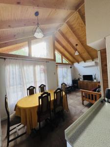a dining room with a yellow table and chairs at Cabaña de Campo tulahuen in Piedra Lisa