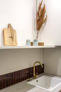 a kitchen counter with a sink and a shelf at Courcelles Parc Monceau in Paris