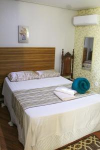 a bedroom with a large bed with a wooden headboard at Apartamento Encantador 9 C in Montes Claros
