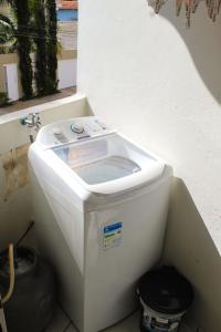 a white toilet sitting in a bathroom next to a wall at Apartamento Encantador 9 C in Montes Claros