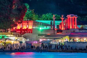 a group of people standing near the water at night at Arcadia City Apartments in Odesa