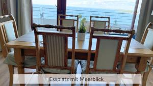 a dining room table with two chairs and a window at Baltic Sea Deck 29 mit Meerblick in Timmendorfer Strand