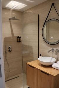 Un baño con lavabo y ducha con espejo. en Adriatic Stay, en Durrës 36 fotos más