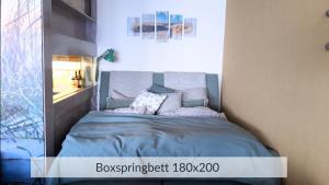 a bedroom with a bed with blue sheets and pillows at Baltic Sea Deck 29 mit Meerblick in Timmendorfer Strand +15 photos