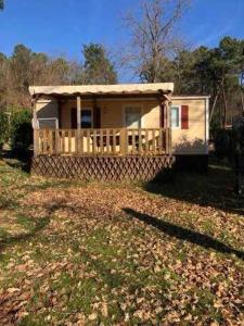a small house with a porch in a yard at Chalet 3 étoiles - Piscine - ccafgfe in Douville