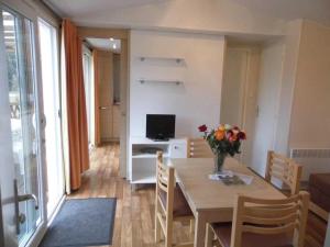 a living room with a table with a vase of flowers at Chalet 3 étoiles - Piscine - ccafgfe in Douville