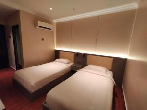 two beds in a hotel room with lights on them at Hotel O GHC Near Penang Street Art Formerly Queen City Hotel in George Town