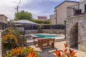 a pool with a wooden table and a bench next to a house at Kuća za odmor ANTICA in Lakmartin
