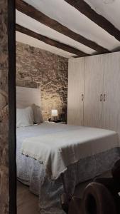 ein Schlafzimmer mit einem Bett und einer Steinwand in der Unterkunft Casa Rural Acogedora en Veguillas de la Sierra in Veguillas de la Sierra + 26 Fotos
