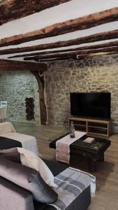 ein Wohnzimmer mit Couch und Flachbildfernseher in der Unterkunft Casa Rural Acogedora en Veguillas de la Sierra in Veguillas de la Sierra