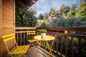 a yellow table and two chairs on a balcony at Reihenvilla Ambachgasse in Caldaro