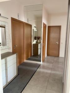 Un baño con dos puertas de madera y un espejo. en Forest gateway, en Jūrmala