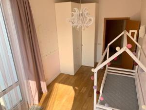 Una habitación con una escalera con una lámpara de araña y un dormitorio. en Forest gateway, en Jūrmala