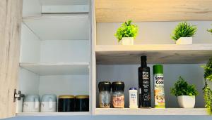 a cupboard with bottles and potted plants on it at Rissie's Place in Gordonʼs Bay