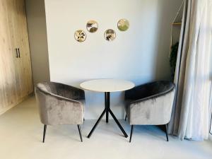 a table and two chairs in a room at Rissie's Place in Gordonʼs Bay